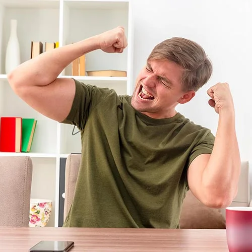 An energized man celebrating with fists raised after receiving IV Nutrition Therapy at a wellness clinic.